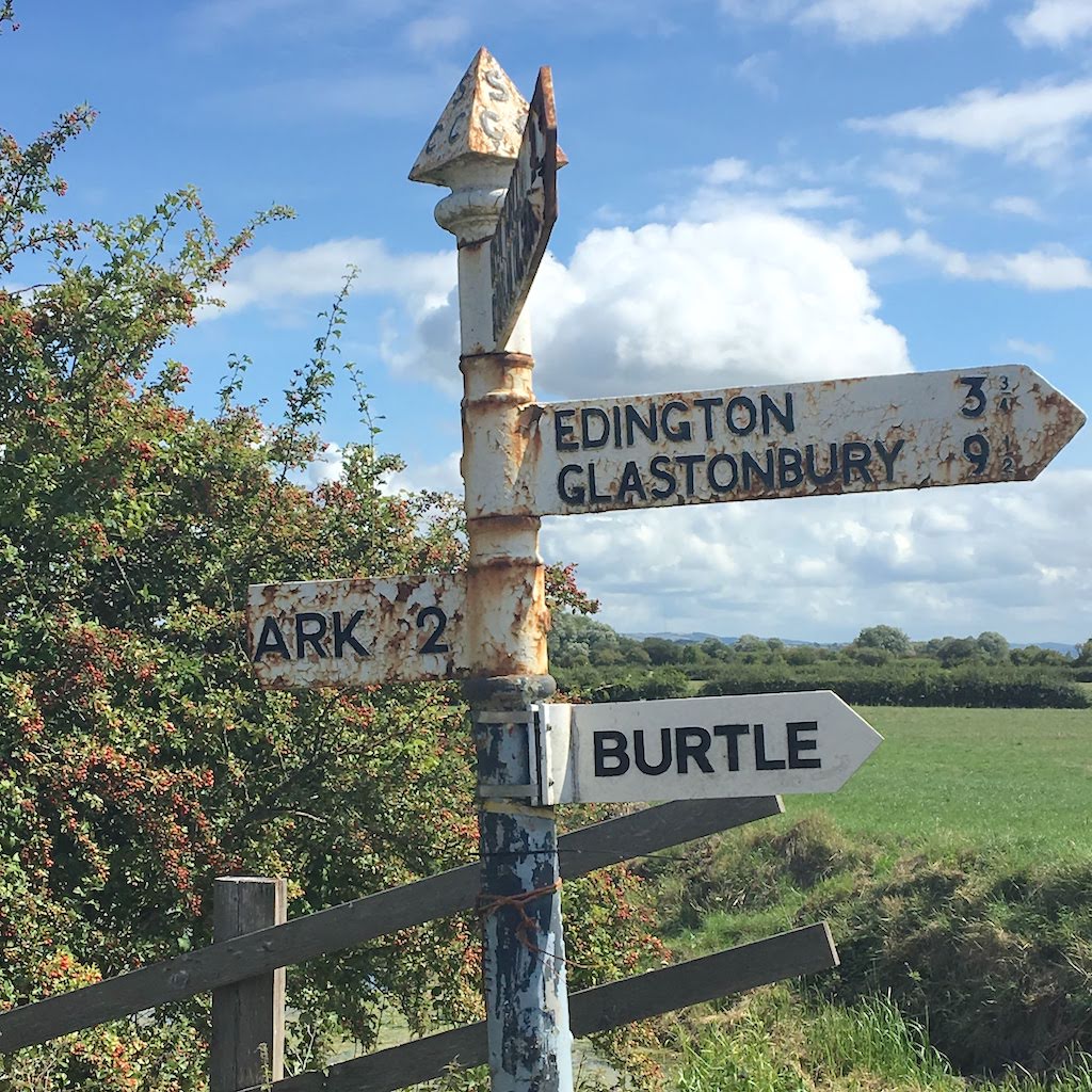 A rusty roadside sign in the countryside