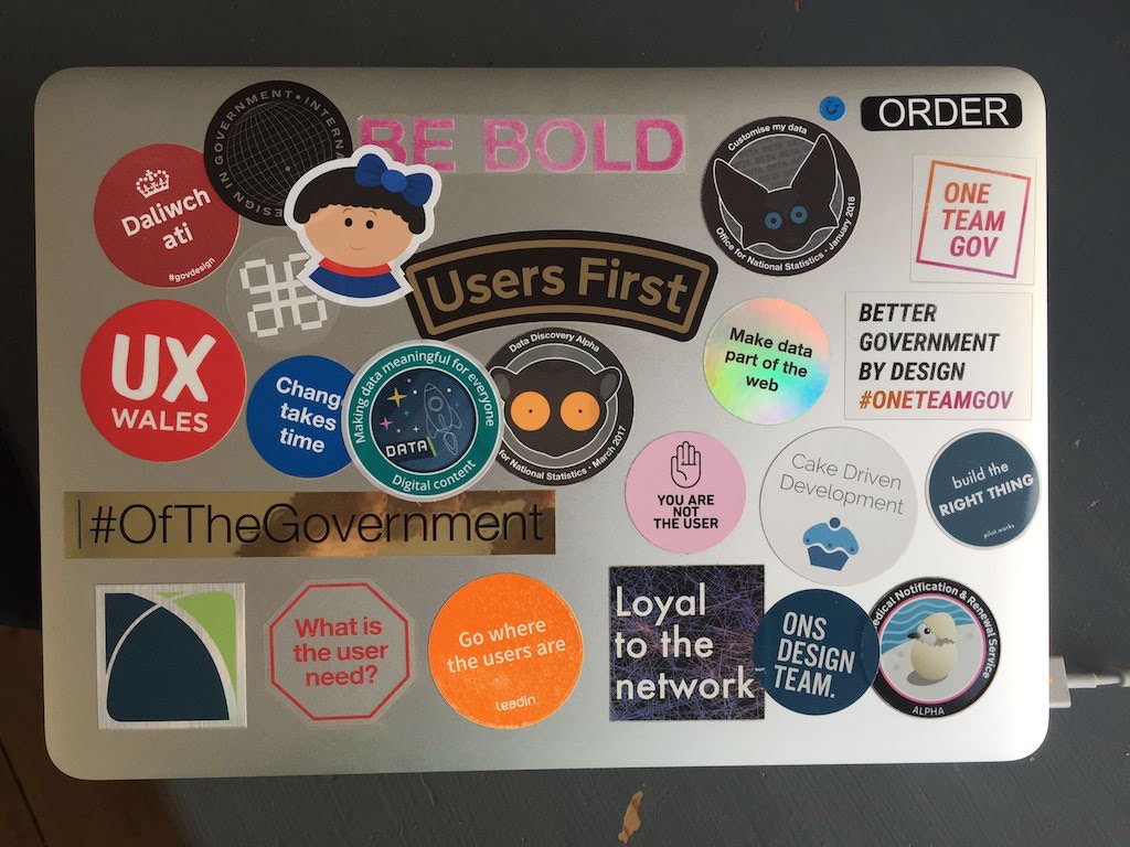 A MacBook Pro lid covered in colourful, mostly circular stickers.